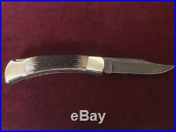 Buck 110 damascus blade folding knife jigged brown bone handle Never used